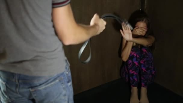 Frightened woman sitting in the corner with a faceless man holding a belt, a conceptual shoot portraying the process and effects of domestic violence — Stock Video