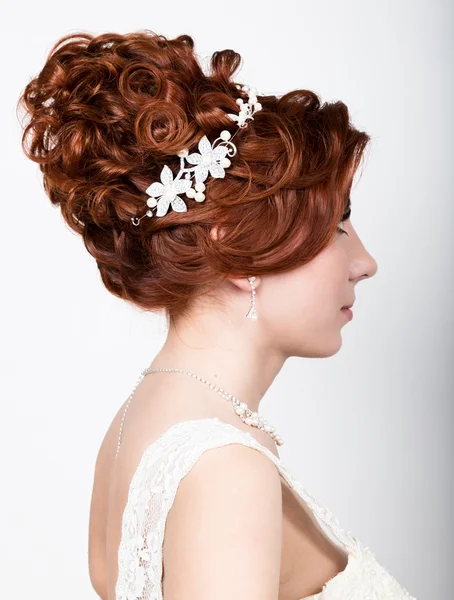 Close-up retrato de jovem noiva bonita em um vestido de noiva com uma maquiagem de casamento e penteado . — Fotografia de Stock