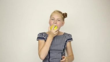 güzel genç kız bir elma yemek çizgili bir elbise giymiş. sağlıklı gıda - güçlü diş kavramı