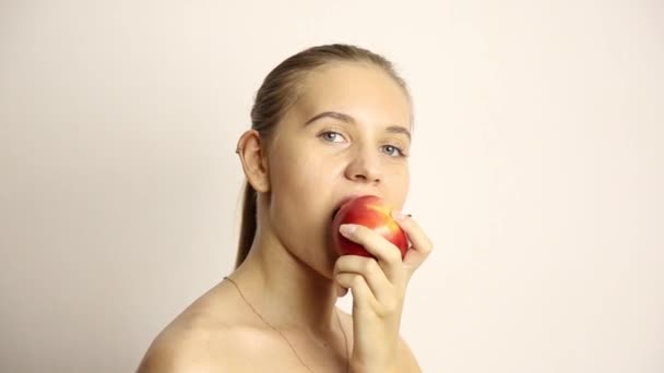 Красива гола молода жінка їсть яблуко. здорова їжа - концепція міцних зубів — стокове відео
