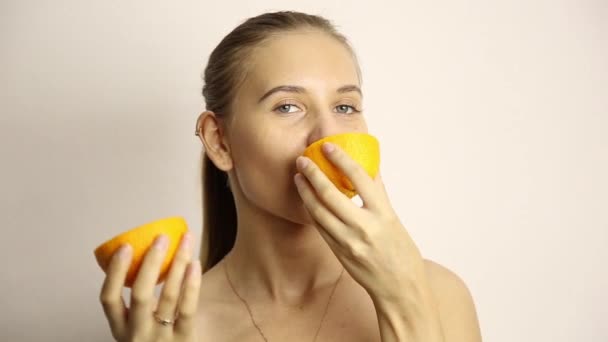 Hermosa mujer joven desnuda comiendo una naranja. comida saludable - concepto de dientes fuertes — Vídeos de Stock