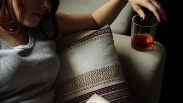 Sad lonely woman drinks alcohol in the dark. Glass in sharp focus. female alcoholism — Stock Video