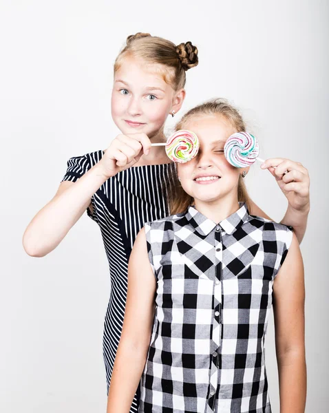 两个可爱小女朋友吃明亮棒棒糖。有趣的孩子们。最好的朋友纵容和构成 — 图库照片