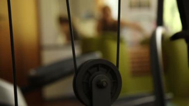 Hangi birisi çalışıyor, aşağı yukarı eşit ağırlıklı hareketli yükler güç simülatörü parçası. bir arka plan üzerinde kız spor için giriyor