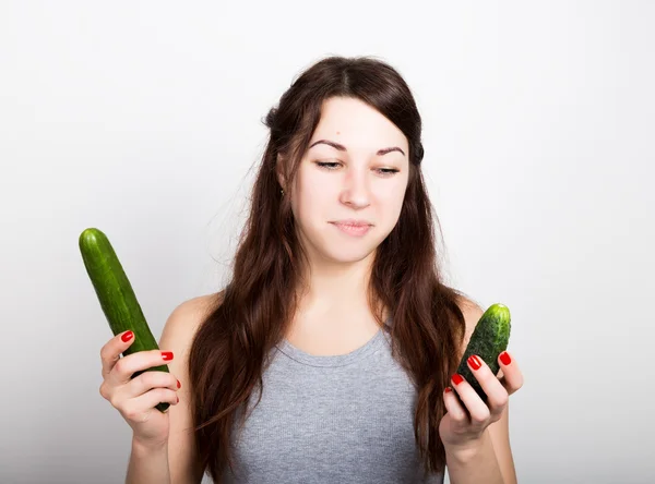 美しい若い女性が、野菜を食べること。選択、小さなまたは大きなキュウリ。健康食品 - 強力な歯のコンセプト — ストック写真