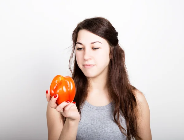 Piękna młoda kobieta jedzenie warzyw. trzymając czerwony pieprz. Zdrowa żywność - silne zęby i ciało koncepcja — Zdjęcie stockowe