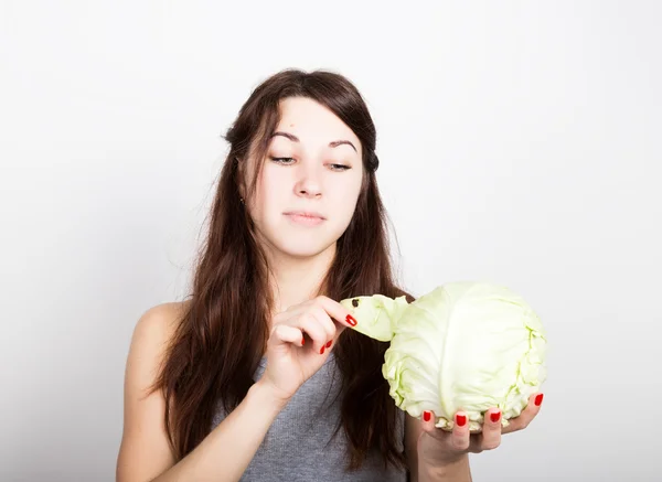 美しい若い女性が、野菜を食べること。彼女を見つめるキャベツを保持、キャベツの頭。健康食品 - 健康なボディのコンセプト — ストック写真