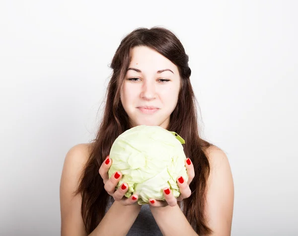 美しい若い女性が、野菜を食べること。彼女を見つめるキャベツを保持、キャベツの頭。健康食品 - 健康なボディのコンセプト — ストック写真