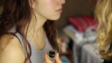 makyaj sanatçısı fırça kullanarak bir güzel kız modeli kaşları boyalar