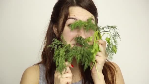 Красива молода жінка їсть овочі. тримає кріп і петрушку. здорове харчування - концепція здорового тіла — стокове відео