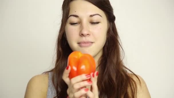 Hermosa mujer joven comiendo verduras. sosteniendo un pimiento rojo. comida saludable - concepto corporal saludable — Vídeo de stock