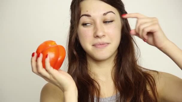 Gyönyörű fiatal nő és zöldséget eszik. a gazdaság egy piros paprika. egészséges ételek - egészséges test fogalma — Stock videók