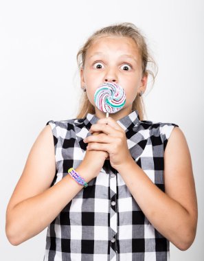 Tatlı candys güzel genç kızla mutlu portre. renkli lolipop tutan bir ekose gömlek giymiş genç ve güzel kız