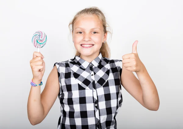 Porträt eines glücklichen schönen jungen Mädchens mit süßen Bonbons. hübsches junges Mädchen in einem karierten Hemd mit buntem Lutscher — Stockfoto