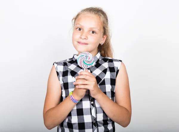 Porträt eines glücklichen schönen jungen Mädchens mit süßen Bonbons. hübsches junges Mädchen in einem karierten Hemd mit buntem Lutscher — Stockfoto