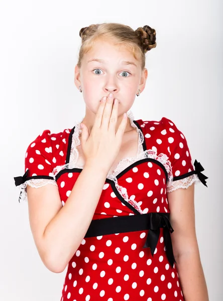 Όμορφο νεαρό κορίτσι ντυμένος με ένα κόκκινο φόρεμα με λευκές πουά. Αστεία παιδιά περιποιηθούν και ποζάρουν — Φωτογραφία Αρχείου