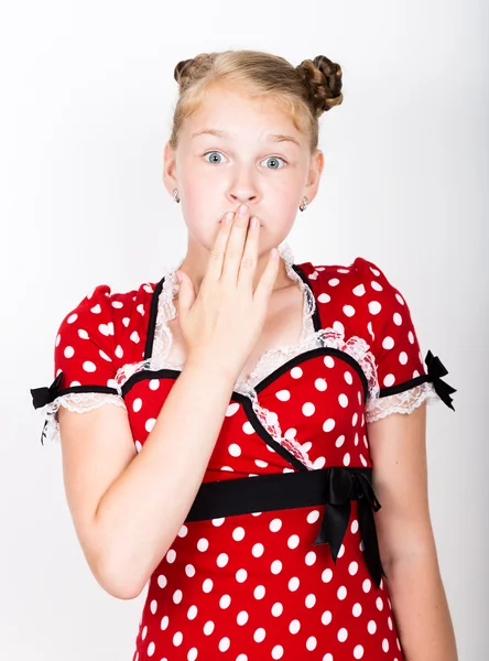 Bela menina vestida com um vestido vermelho com bolinhas brancas. Engraçado crianças mimar e posar — Fotografia de Stock