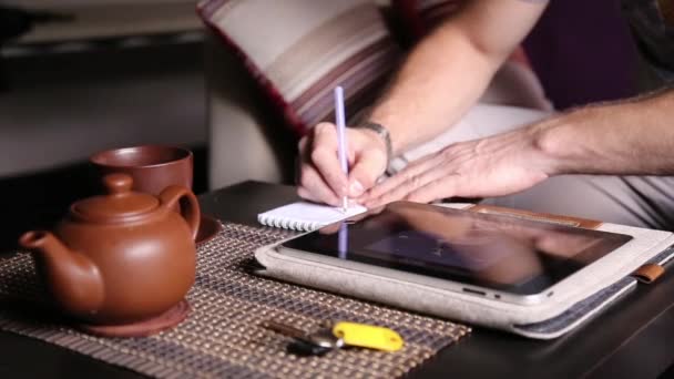 在线购物和做笔记在笔记本中使用平板电脑的年轻商人。在 pc tablet 上工作，在咖啡厅喝下午茶的人 — 图库视频影像