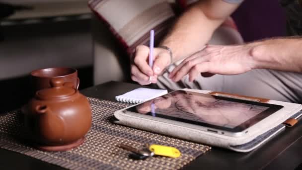 Genç işadamı online alışveriş ve notları bir dizüstü bilgisayarda yapmak için tablet bilgisayar kullanarak. PC tablet üzerinde çalışan ve kafede çay içme adam — Stok video