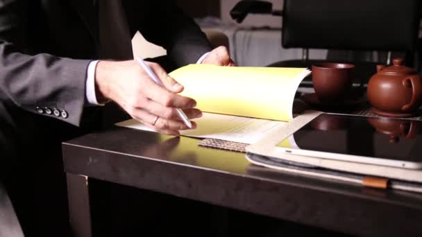 Empresario sentado escritorio de la oficina firma un proyecto de ley que los compara, con la tableta de PC. las manos de un hombre y una pluma estilográfica — Vídeo de stock