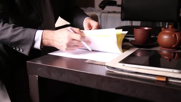 Homme d'affaires assis bureau signe un projet de loi les comparant, avec la tablette PC. mains rapprochées d'un homme et d'un stylo plume — Video