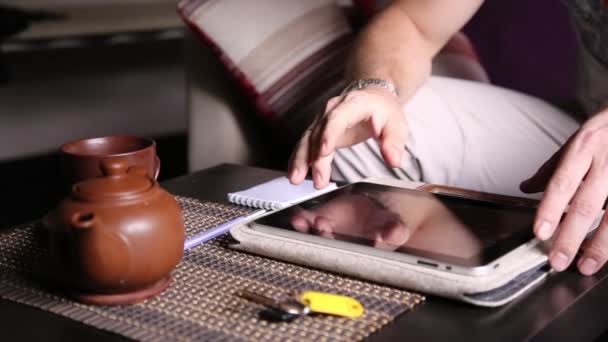 Genç işadamı online alışveriş ve notları bir dizüstü bilgisayarda yapmak için tablet bilgisayar kullanarak. PC tablet üzerinde çalışan ve kafede çay içme adam — Stok video