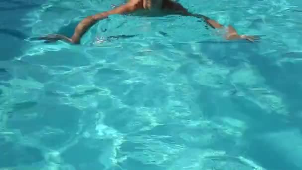 Jovem mulher feliz nadando em uma piscina — Vídeo de Stock