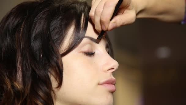 Tempo em um salão de beleza. Uma jovem num salão de beleza. Stylist faz noiva maquiagem no dia do casamento. escova de pó cosmético para maquiagem. pele perfeita — Vídeo de Stock