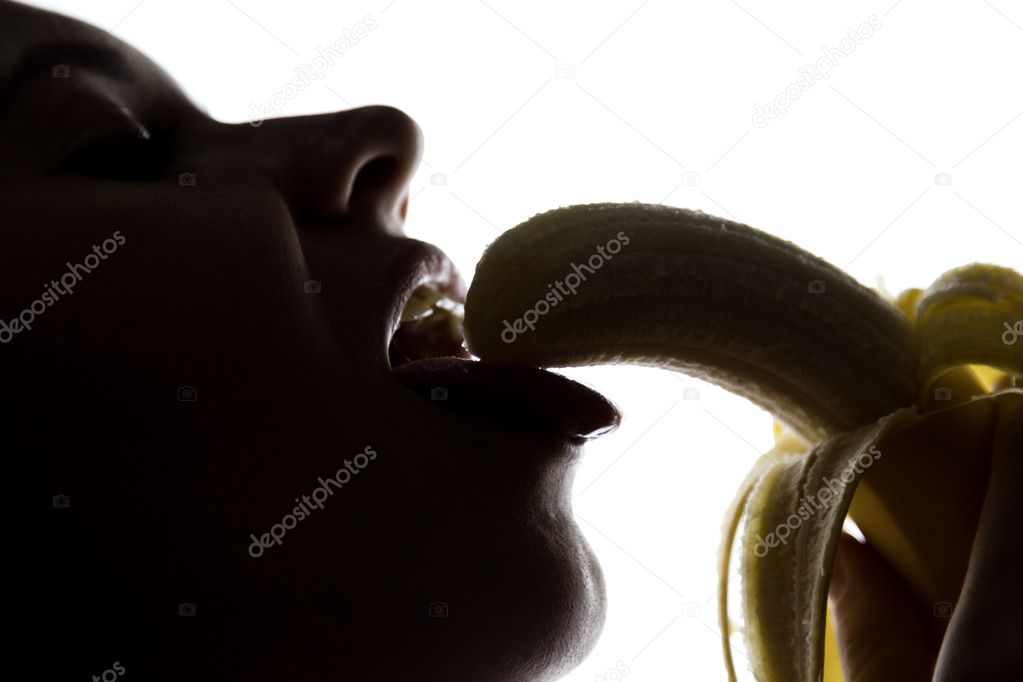 Close-up of Young amazed woman holding a banana, she is going to eat a banana. she sucks a banana