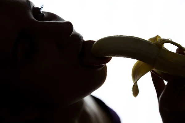 Primo piano di Giovane donna stupita in possesso di banana, sta per mangiare una banana. succhia una banana — Foto Stock