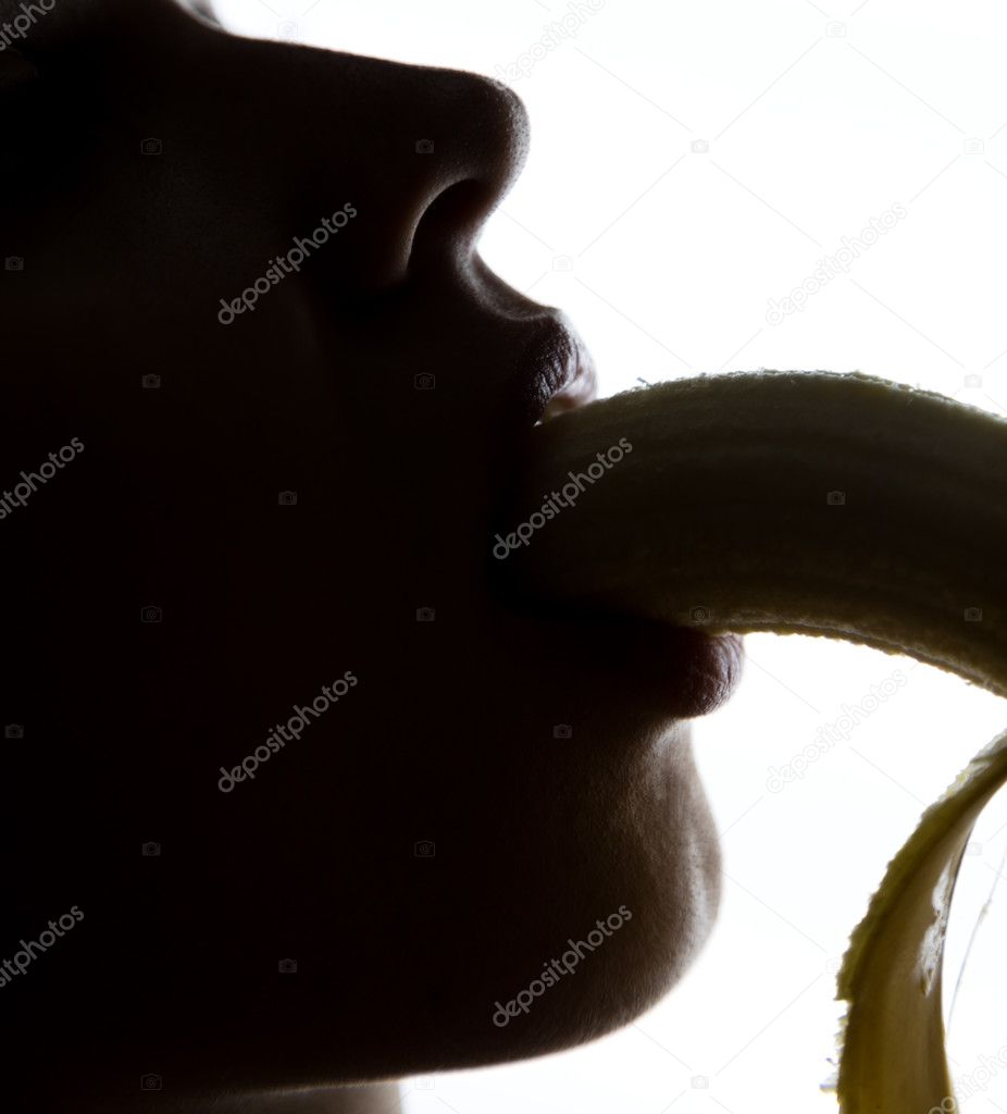 Close-up of Young amazed woman holding banana, she is going to eat a banana. she sucks a banana