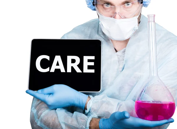 Γιατρός με χειρουργική στολή, κρατώντας ροζ φιάλη και ψηφιακό Tablet PC με σήμα φροντίδας. διαδικτυακή τεχνολογία και τη δικτύωση στην έννοια της ιατρικής. Απομονωμένος σε λευκό — Φωτογραφία Αρχείου