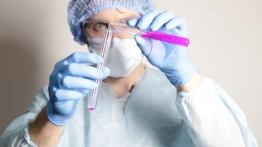 şişesi tutarak ve deney ilerlemesini izlerken bilim adamı doktor tıbbi üniformalı
