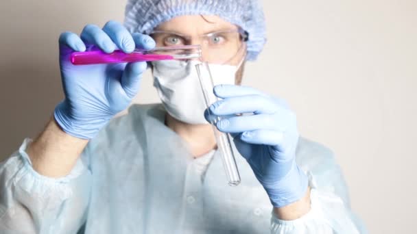 Ученый врач в медицинской форме, держит фляжку и наблюдает за ходом эксперимента — стоковое видео