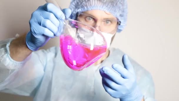 Scientist doctor in medical uniform, holding flask and watching the progress of experiment — Stock Video