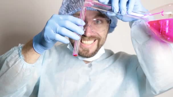 Επιστήμονας ιατρός στην ιατρική στολή, κρατώντας φιάλη και να παρακολουθείτε την πρόοδο του πειράματος — Αρχείο Βίντεο