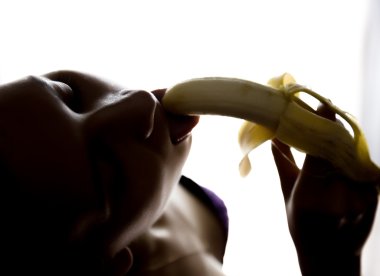 Young beautiful woman in lacy lingerie holding a banana, she is going to eat a banana. she sucks a banana clipart