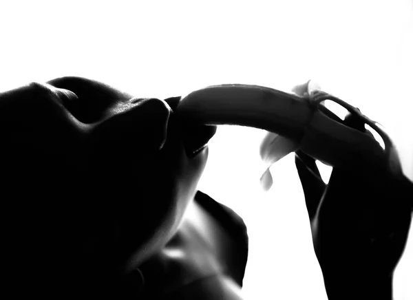 Dantelli iç çamaşırı bir muz tutan genç güzel kadın, muz yemek için gidiyor. o bir muz berbat. siyah ve beyaz