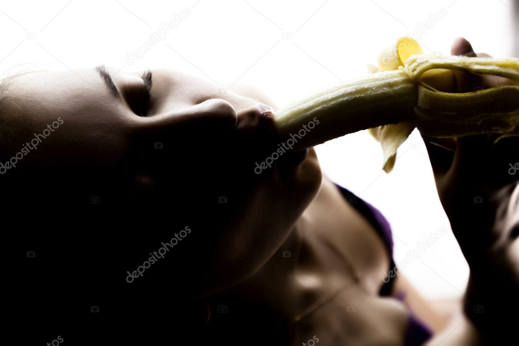 Young beautiful woman in lacy lingerie holding a banana, she is going to eat a banana. she sucks a banana