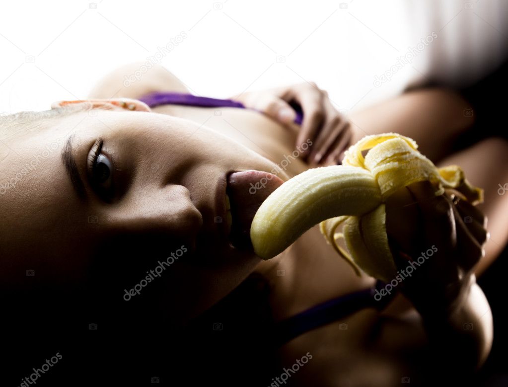 Young beautiful woman in lacy lingerie holding a banana, she is going to eat a banana. she sucks a banana