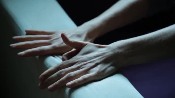 Close-up van de handen van een jonge vrouw liggend op een slechte. Meisje verfrommelt Bank — Stockvideo