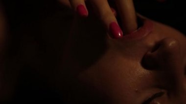 bir parmak yalama karanlık bir arka plan üzerinde yakın çekim güzel kadın