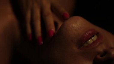 bir parmak yalama karanlık bir arka plan üzerinde yakın çekim güzel kadın