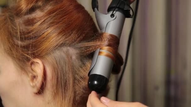 Время в салоне красоты. Молодая женщина в салоне красоты, парикмахер делает прическу с кудряшками для красивой модели — стоковое видео