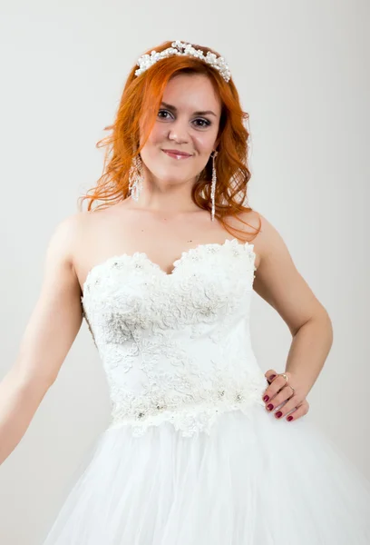 Noiva ruiva em um vestido de noiva, aparência excepcional brilhante. Penteado de casamento bonito e maquiagem brilhante — Fotografia de Stock