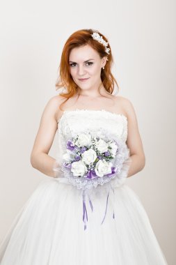 düğün buketi tutan bir gelinlik kızıl saçlı gelin, parlak sıradışı bir görünüm. Güzel düğün saç modeli ve parlak makyaj