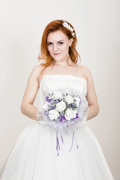 Pengantin berambut merah dalam gaun pengantin memegang buket pengantin, penampilan yang tidak biasa cerah. Indah gaya rambut pernikahan dan riasan cerah — Stok Foto