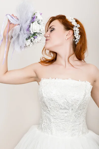 結婚式のブーケを保持するウェディングドレスで赤毛の花嫁、明るい珍しい外観。美しい結婚式の髪型と明るいメイクアップ — ストック写真