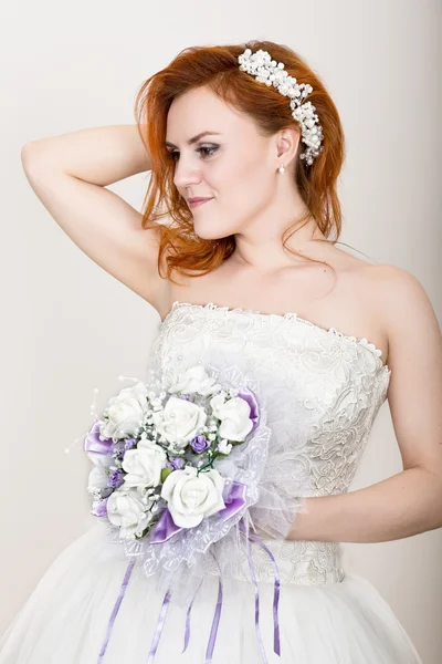 Noiva ruiva em um vestido de noiva segurando buquê de casamento, aparência incomum brilhante. Penteado de casamento bonito e maquiagem brilhante — Fotografia de Stock