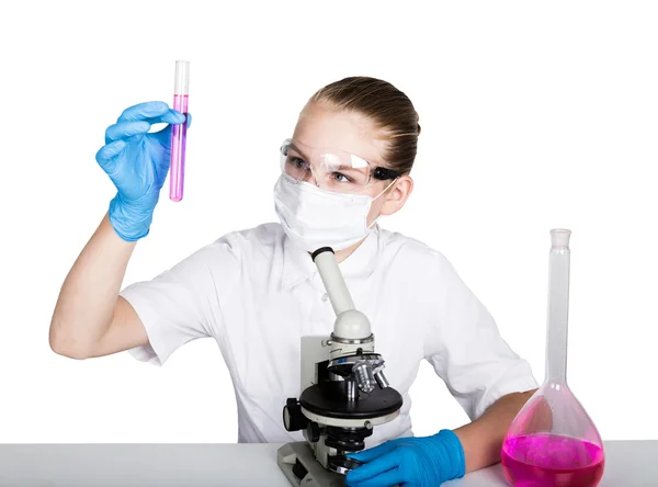 Уважна школярка проводить хімічний експеримент на уроці початкової науки. вивчення бактерій через мікроскоп — стокове фото
